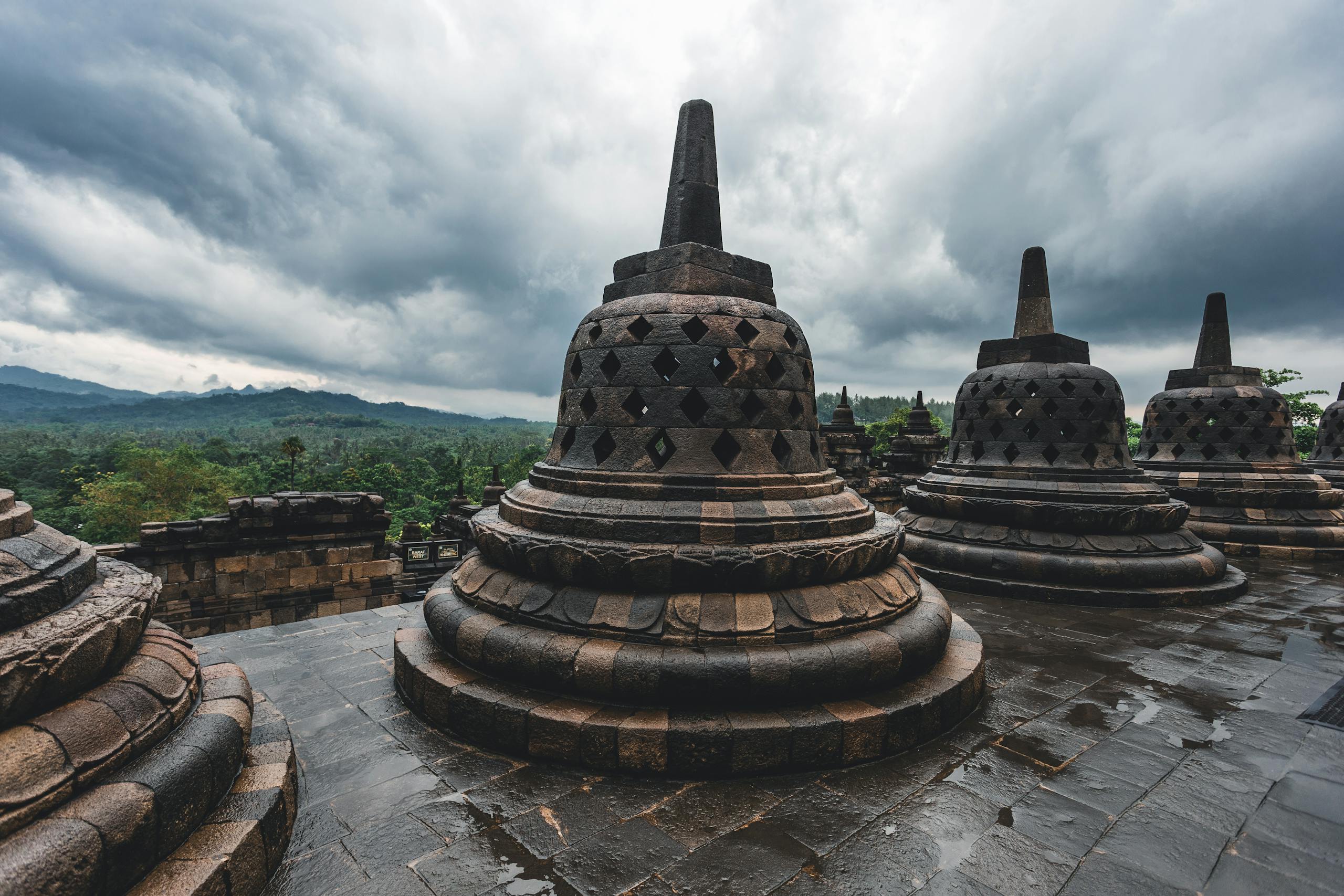 Stunning stupas at Borobudur Temple in Indonesia under dramatic cloudy skies.